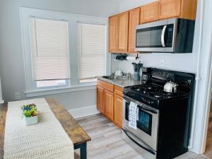 a kitchen with a black stove and a microwave at Cozy Corner, stylish 1bed near Navy Base! in Waukegan
