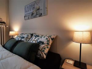 una camera da letto con un letto con un cuscino e due lampade di Gîte "Le temps d'une pause" terrasse et piscine a Coubon Altre 24 foto