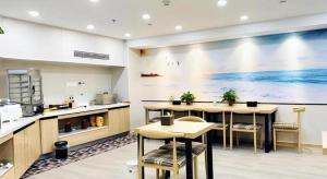 a restaurant with a large painting on the wall at Green Tree Inn Express Jiangsu Taizhou Xinghua RT-Mart in Xinghua