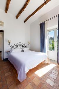 a white bedroom with a large bed and a window at Relais Regina Giovanna in Sorrento