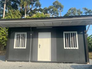 a garage with a white door and two windows at Ar-Rani Roomstay in Jerantut