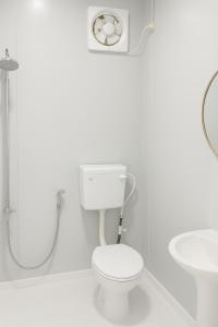 Un baño blanco con inodoro y lavabo. en Ar-Rani Roomstay, en Jerantut