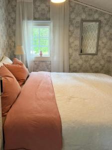 a bedroom with a large bed and a window at Cosy Forest Cabin Near Bollnäs in Bollnäs
