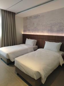 two beds in a hotel room with white sheets at The Jerai Hotel Sungai Petani in Sungai Petani +36 photos