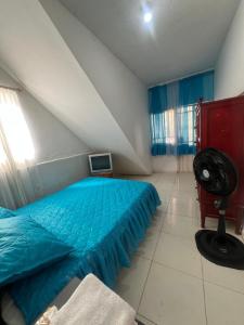 a bedroom with a blue bed and a fan at Habitacion acceso independiente mejor ubicacion in Cúcuta
