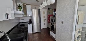 une cuisine avec un réfrigérateur et des armoires en acier inoxydable dans l'établissement Relaxing experience in apt club nautico isleta, à La Manga del Mar Meno