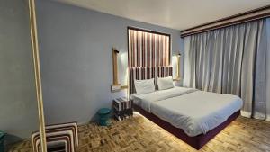 una camera da letto con un letto e una grande finestra di Resort Saffron a Manāli