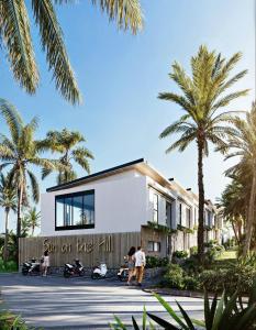 un bâtiment avec des palmiers devant dans l'établissement Sun of the hill, à Nusa Dua