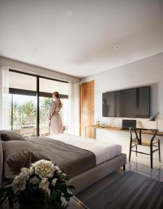 une femme debout dans une chambre avec un grand lit dans l'établissement Sun of the hill, à Nusa Dua