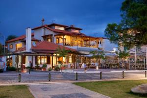 a large white building with a lot of windows at Traditional Arsanas Apartments in Nikiti