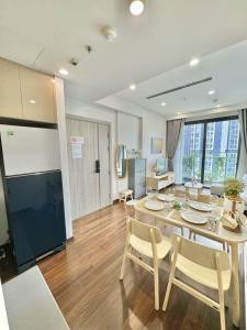 Un comedor y una sala de estar con mesa y sillas. en Vinhomes Smart City Luxury Apartment, en Phú Thú