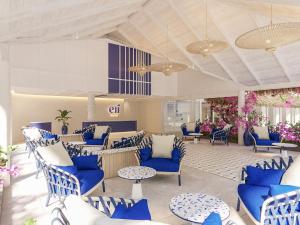 a lobby with blue chairs and tables and flowers at Eri Maldives in North Male Atoll