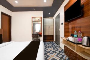 um quarto de hotel com uma cama e uma TV de tela plana em Collection O Sea Beach Puri Formerly Hotel BB Palace em Puri