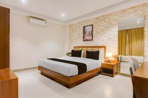 a hotel room with a bed and a television at Super Townhouse Oak Sevoke Road Siliguri in Siliguri +22 photos