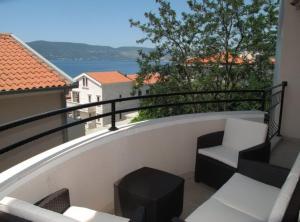 a balcony with chairs and a view of the water at Villa Apartments Kumbor President in Kumbor