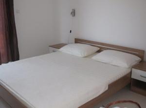 a bedroom with a large white bed with two pillows at Villa Apartments Kumbor President in Kumbor