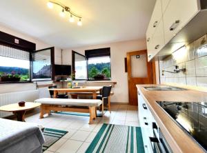 a kitchen with a table and a dining room at Holiday Apartment Vuković in Saborsko
