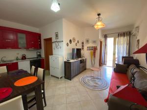 a kitchen and a living room with a couch and a table at Little Pearl in Orikum