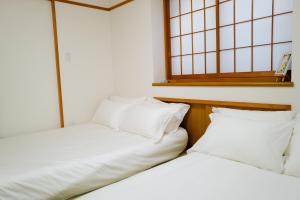 two beds sitting next to each other in a room at Akira Hiro House - Room101 in Tokyo