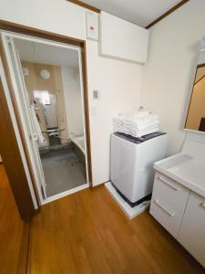 a room with a bathroom with a sink and a refrigerator at Akira Hiro House - Room101 in Tokyo