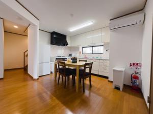 a kitchen with a table and chairs in a room at Akira Hiro House - Room101 in Tokyo