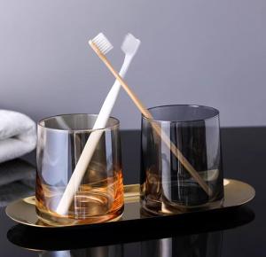 two glasses with toothbrushes in them on a table at Zhangjiajie MUYE HOTEL in Jiawan