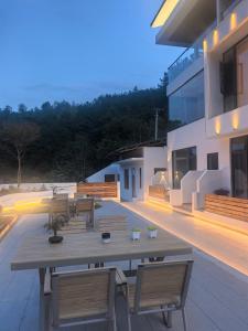 a patio with a wooden table and chairs on a building at Zhangjiajie MUYE HOTEL in Jiawan