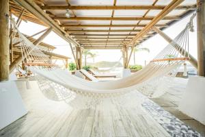 a hammock in a room with a table and chairs at Villa Paradise - Blue Venao 3BR in Playa Venao +24 photos
