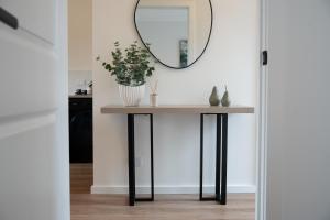 a console table with a mirror on the wall at Moritz Hahndorf Boutique Guest House in Hahndorf