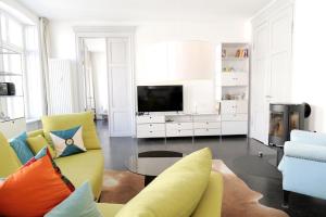 sala de estar con sillas amarillas y azules y TV en Zuhause am Boulevard - ABC40, en Wismar