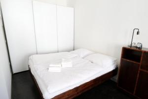Cama en habitación con sábanas y almohadas blancas en Zuhause am Boulevard - ABC40, en Wismar