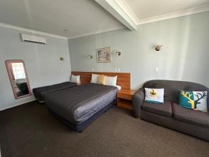 a hotel room with a bed and a couch at Colonial Motor Lodge Scone in Scone