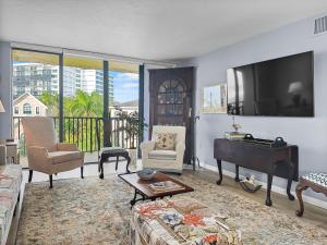 a living room with a flat screen tv and a piano at Sandy Cove in Bailey Hall +18 photos