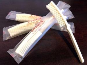 a toothbrush and two toothpaste packets on a table at ホテルリブマックス那覇波の上2 in Naha