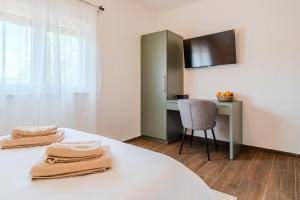 Un dormitorio con una cama con dos toallas encima. en Plitvice Lakes Apartments & Rooms, en Grabovac