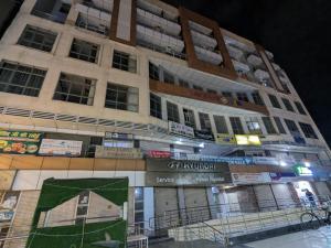 ガーズィヤーバードにあるABVP Studioの夜間の標識が付いた高層ビル +4枚の写真