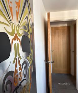 a hallway with a painting of a mask next to a door at Boutique 1 Bedroom Duplex Suite on Marina-304 in Hull