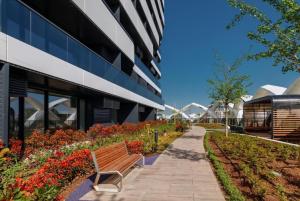 a bench in front of a building with flowers at Deluxe Studio NRG U-Tower in Tashkent