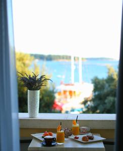 a table with two plates of food and orange juice at Boutique Hotel Mauro in Poreč