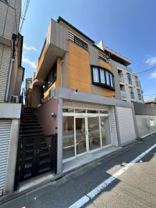 a building with a store with glass doors on a street at Akira Hiro House - Room102 in Tokyo
