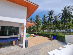 a backyard with a swimming pool and palm trees at Hadkaew Thepha Pool Villa by Jehsana in Ban Krong I Tam