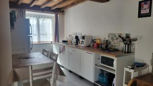 a kitchen with a table and a white refrigerator at Maison de campagne in Issor