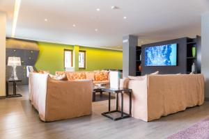 uma sala de estar com sofás e uma televisão de ecrã plano em Hotel Europa em Breuil-Cervinia
