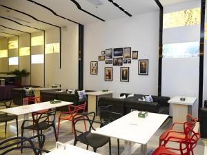 a restaurant with white tables and red chairs at LAVANDE Hotel Dalian Huanan Square North Railway Station in Dalian