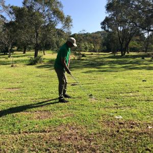 a man is playing golf in a field at Ahaspokuna by Eco Team in Belihuloya