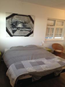 um quarto com uma cama e uma fotografia na parede em Prins van Poederoijen em Poederoijen