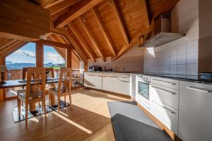 Una cocina con gabinetes blancos y una mesa con sillas. en Apartments Sunela, en Selva di Val Gardena