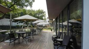 an outdoor patio with tables and chairs and umbrellas at Jinjiang Metropolo Shanghai Minhang in Shanghai