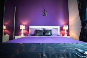 ein lila Schlafzimmer mit einem Bett mit lila Wänden in der Unterkunft Luxury apartment Lavande in Pridraga