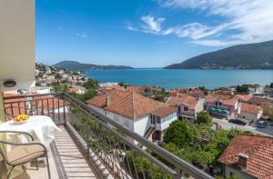 a balcony with a view of a town and the water at Adriana Apartments in Herceg-Novi